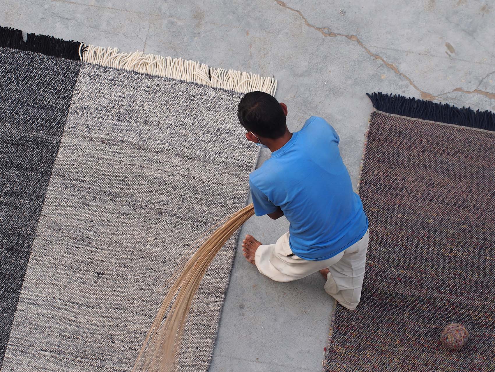Indian artisan working on the rug Re-Rug designed by Nani Marquina.