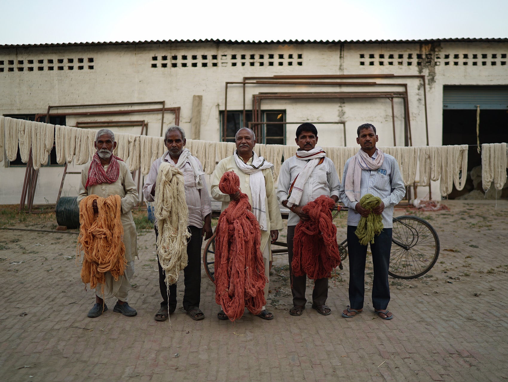 Indian artisans holding recycled fibers used for the Re-Rug collection.